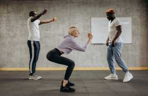 Home Personal trainer begeleidt cliënt bij trainingsoefening in de sportschool