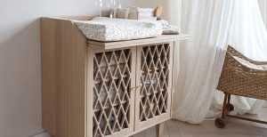Scandinavische babykamer inrichting met organisch beddengoed, houten meubels en accessoires in minimalistisch design